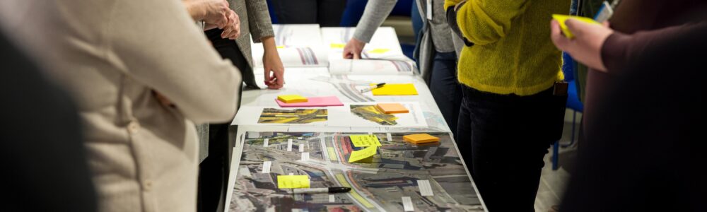 Henkilöitä katusuunnitelmien äärellä.