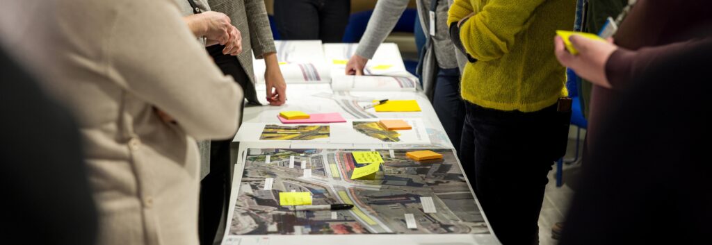 Henkilöitä katusuunnitelmien äärellä.