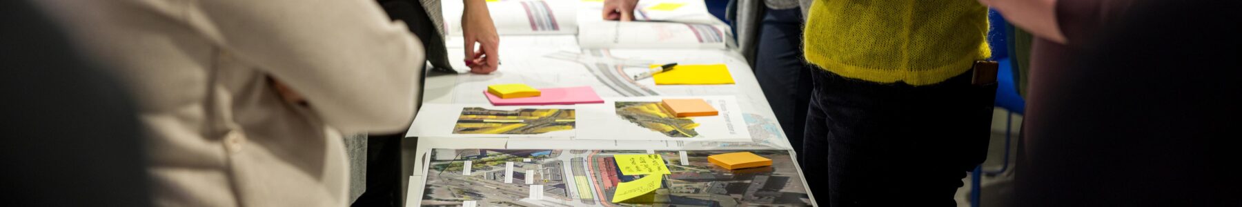 Henkilöitä katusuunnitelmien äärellä.