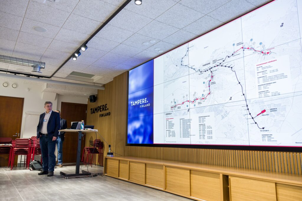 Kuvituskuva yleisötilaisuudesta, jossa Tampereen Raitiotie Oy:n kehitysjohtaja Ville-Mikael Tuominen esittelee raitiotien linjausta.