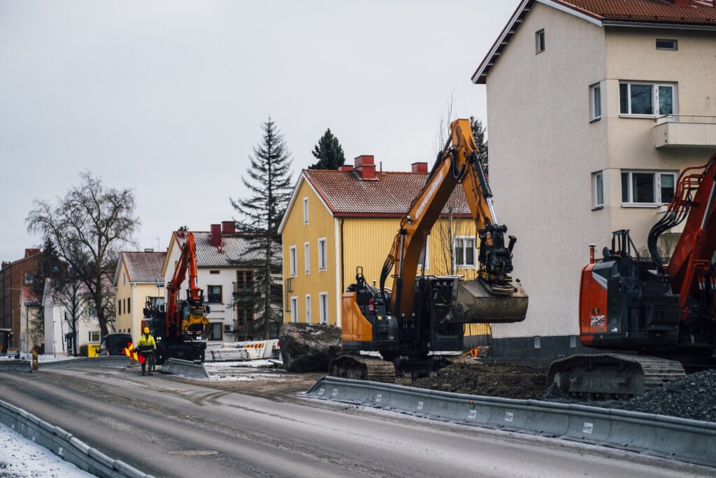Työkoneita ja rakennustyöntekijöitä raitiotietyömaalla Nuolialantiellä talvella 2025